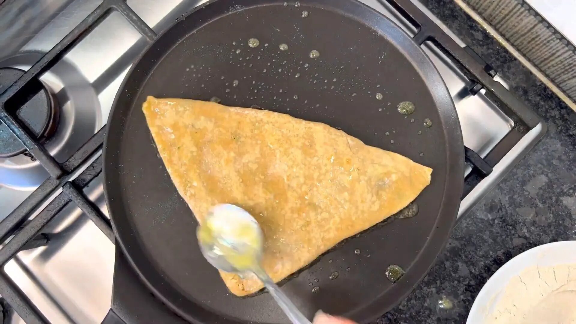 Cooking the stuffed paratha on a tawa